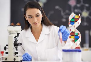 fear of spiders treatment - female scientist working on phobia research in a white lab coat with a microscope and dna model.