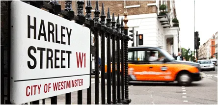 Harley Street sign with blurred Taxi in background
