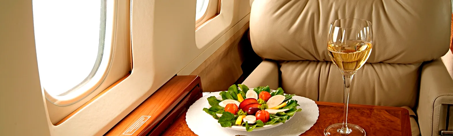 UK Fear of flying Course - Aeroplane first class seat with delicious fresh salad and white wine on table