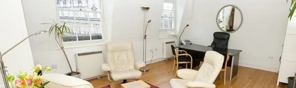The treatment room with a desk and recliner chairs for phobia hypnotherapy at the phobiaman clinic in Harley Street